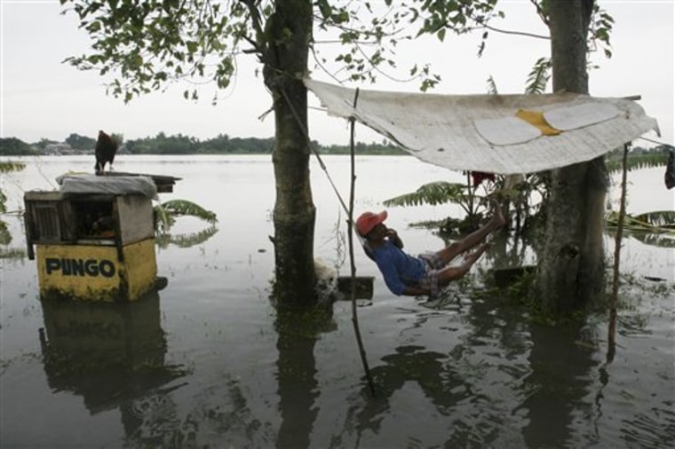 A resident relaxes on a hammock as he sets up temporary shelter along a road as massive flooding continues for the second day Saturday, Oct. 1, 2011 at Calumpit township, Bulacan province north of Manila, Philippines. Typhoon Nalgae, the second typhoon in a week to hit the rain-soaked northern Philippines, added misery to thousands of people, some of whom are still perched on rooftops while several other Asian nations also reeled from flooding. (AP Photo/Bullit Marquez)